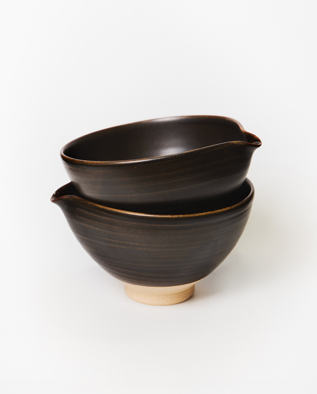 Two black ceramic bowls stacked on a white background